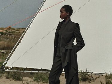 Schwarze Frau vor einem Zelt vor einer Landschaft