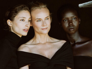 Drei Frauen unterschiedlicher Hautfarbe stehen zusammen